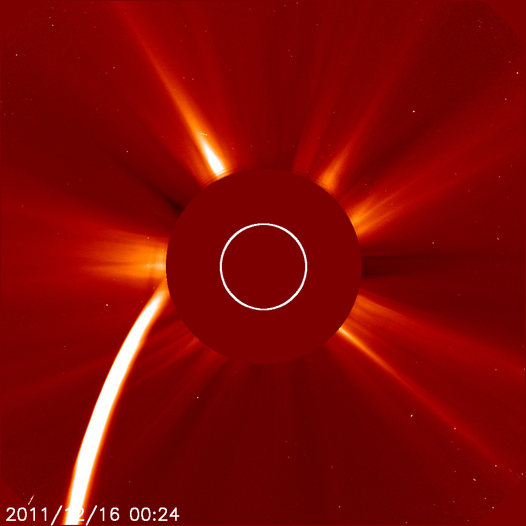 Komet Lovejoy på vei inn mot Solen. Vi ser den enorme halen av stoffer fra kometkjernen. Hodet og kjernen til kometen er allerede bak skiven som beskytter kameraet mot den intense solstrålingen. Den hvite sirkelen viser hvor Solen befinner seg. Foto: SOHO/ESA/NASA.