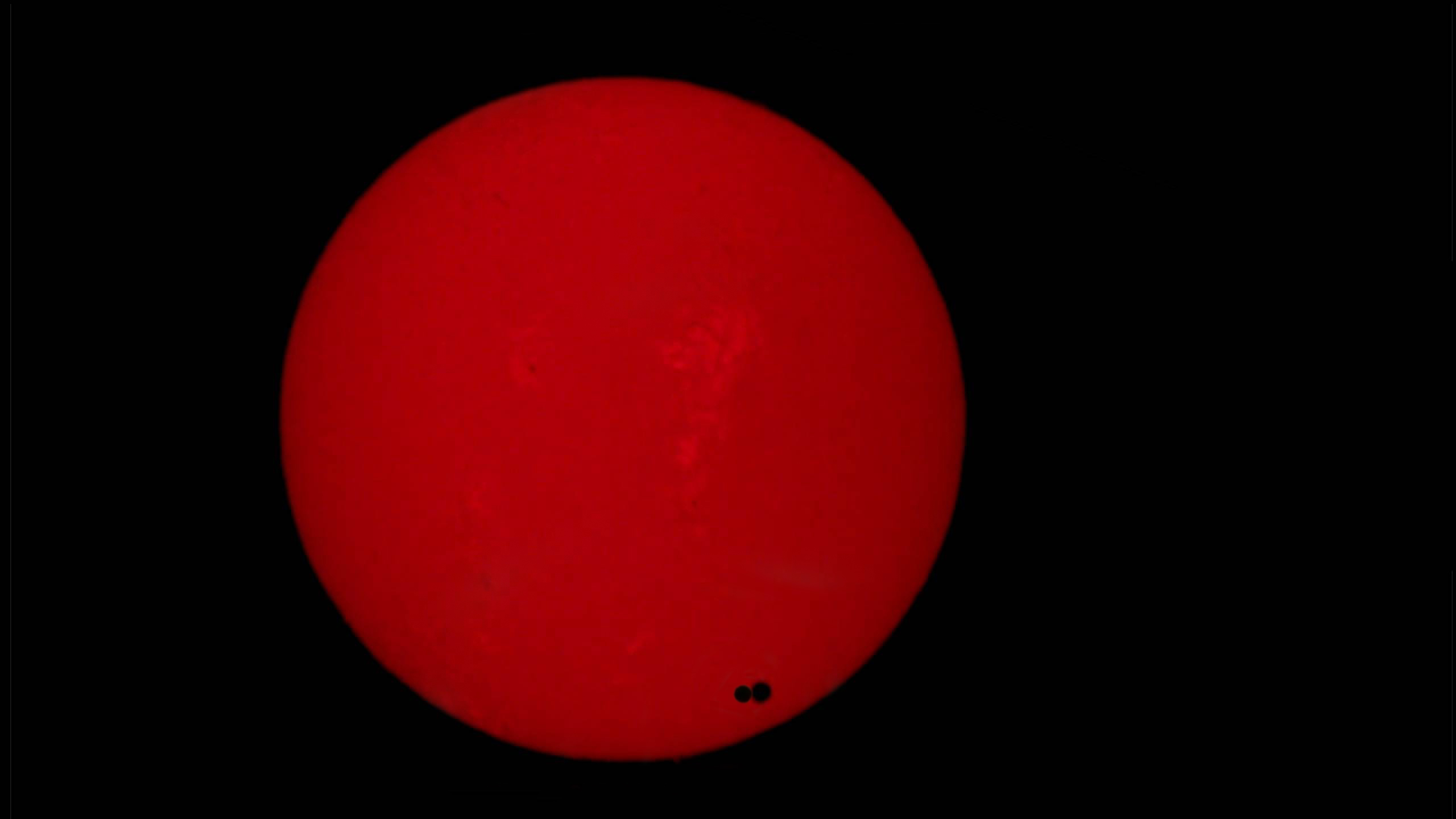 Det er dette Venus-passasjene har handlet om! Bildet er satt sammen av bilder fra Hawaii (høyre Venus-flekk) og Tromsø (venstre Venus-flekk). Fra disse to stedene ble Venus sett i litt ulik retning mot solskiven. Ved å måle avstanden mellom flekkene, kan avstanden til Solen lett regnes ut.  Foto: NASA, Tromsø Astronomiforening, montasje: Trym Norman Sannes
