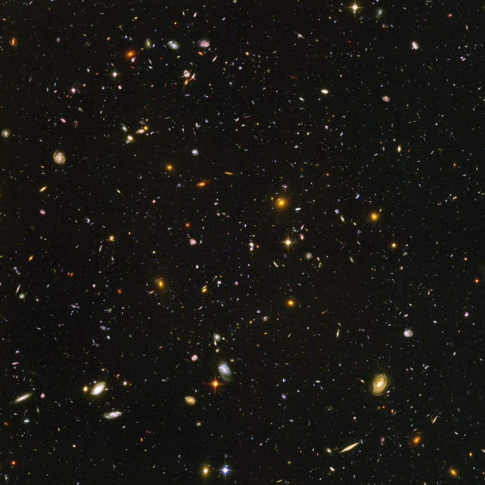 En titt ut i uendeligheten! De fleste flekkene på dette bildet er melkeveier, hver med kanskje 100 milliarder soler, som befinner seg 10-12 milliarder lysår fra Jorden. Foto: ESA/NASA/STScI
