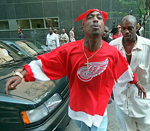 Et bilde tatt av en spyttende Tupac Shakur, på vei ut av en rettsal i juli 1994. To år etter ble han skutt og drept. Foto: NTB Scanpix / Bebeto Matthews, AP Photo.